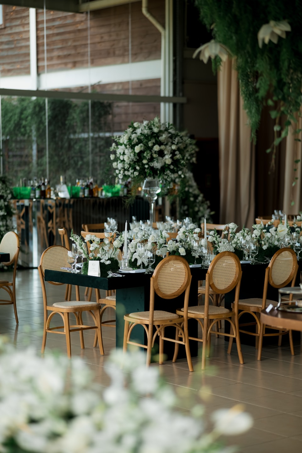 Elegant reception tables with white floral arrangements and candles.