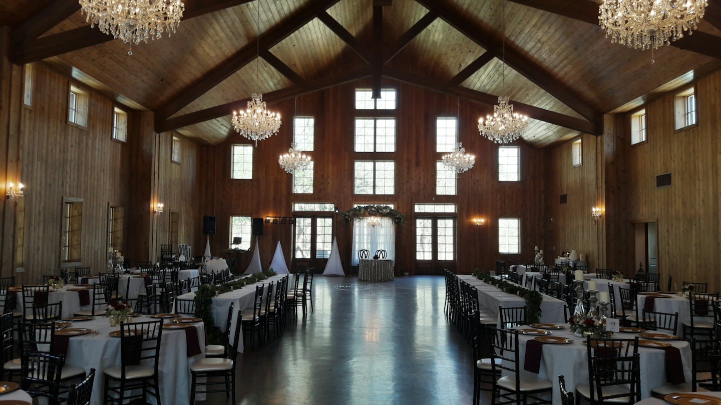 Elegant wedding reception hall with dressed tables and chandeliers.